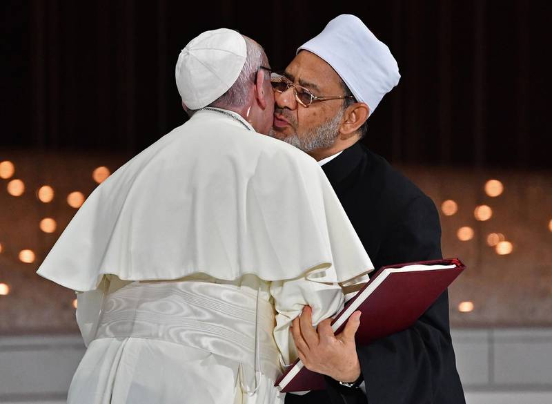 Pope Francis (L) and Egypt's Azhar Grand Imam Sheikh Ahmed al-Tayeb greet each other as they exchange documents during the Human Fraternity Meeting at the Founders Memorial in Abu Dhabi on February 4, 2019. Pope Francis rejected "hatred and violence" in the name of God, on the first visit by the head of the Catholic church to the Muslim-majority Arabian Peninsula. / AFP / Vincenzo PINTO                      
