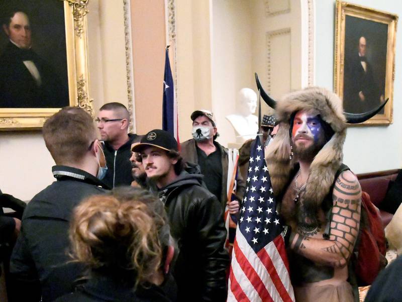 FILE PHOTO: Jacob Anthony Chansley, also known as Jake Angeli, of Arizona, stands with other supporters of U.S. President Donald Trump as they demonstrate on the second floor of the U.S. Capitol near the entrance to the Senate after breaching security defenses, in Washington, U.S., January 6, 2021. REUTERS/Mike Theiler/File Photo