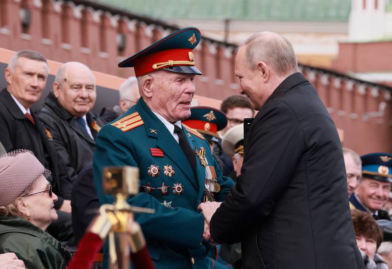 Vladimir Putin shakes hands with spectators before the parade in Moscow. Reuters