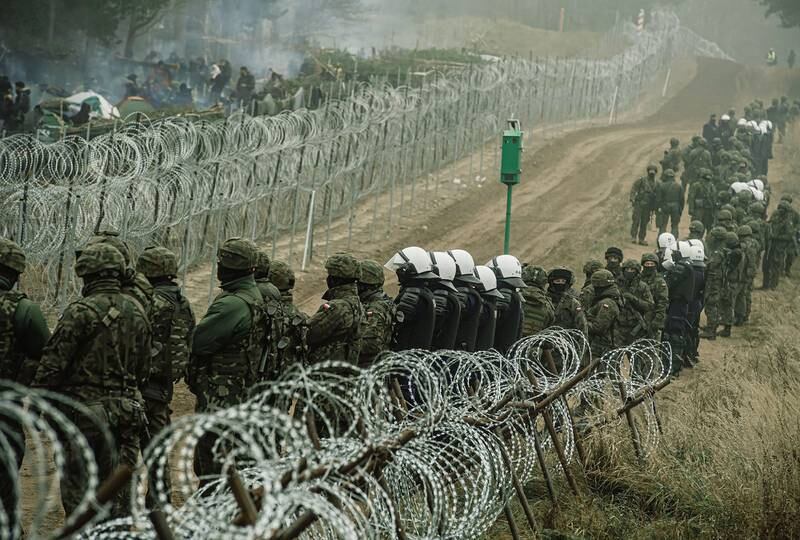 Polish soldiers, police forces and border guard officers at the border fence in Kuznica, eastern Poland. EPA