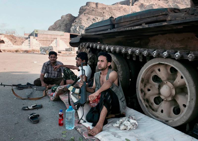 In this file photo taken Saturday, March 21, 2015, members of a militia group loyal to Yemen's President Abed Rabbo Mansour Hadi, known as the Popular Committees, chew qat, Yemen's favorite drug, as they sit next to their tank, guarding a major intersection in Aden, Yemen.   The United Arab Emirates, one of the most powerful parties in Yemenâ€™s war, has begun to draw down its forces in past weeks in 2019, leaving the Saudi-led coalition with a weakened ground presence and fewer tactical options. The withdrawal of several thousand troops comes amid heightened tensions between the United States and Iran, and as the Iranian-allied Yemeni rebels known as Houthis increase their attacks on Saudi Arabia.(AP Photo/Hamza Hendawi, File)