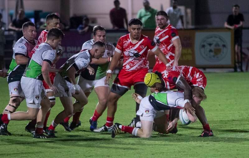 Andrew Semple of Abu Dhabi Harlequins gets tackled by Dubai Tigers players.