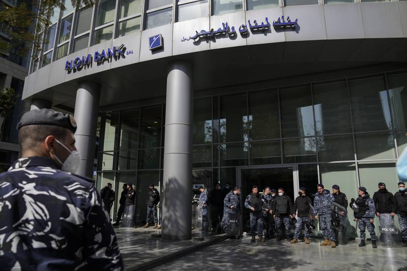 Riot police stand guard in front of a Lebanese bank after depositors tried to storm a lender in Beirut. A dizzying currency collapse has left many people watching on helplessly as their savings evaporate. AP