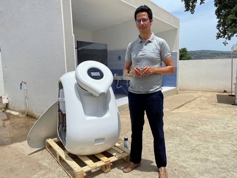 Iheb Triki, co-founder of water tech startup 'Kumulus' stands next to Kumulus-1, a machine that creates drinking water from air moisture, at El Bayadha elementary school, in Jendouba, Tunisia, June 2, 2022.  Picture taken June 2, 2022.  REUTERS / Jihed Abidellaoui