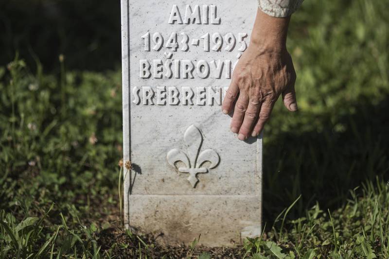 A Bosnian Muslim woman cleans a gravestone of her relative  at the cemetery in Potocari near Srebrenica, Bosnia and Herzegovina. Getty Images