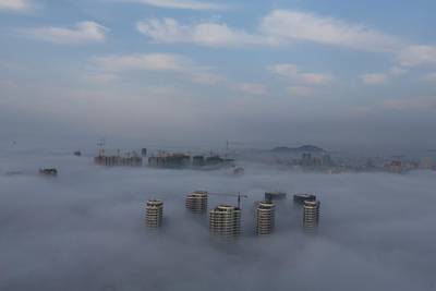 Buildings and construction sites are seen among fog in Rizhao, Shandong province, China. Reuters