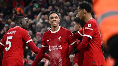 Liverpool's English defender #66 Trent Alexander-Arnold (C) celebrates with teammates after scoring their fourth goal during the English Premier League football match between Liverpool and Fulham at Anfield in Liverpool, northwest England, on December 3, 2023.  (Photo by Paul ELLIS / AFP) / RESTRICTED TO EDITORIAL USE.  No use with unauthorized audio, video, data, fixture lists, club/league logos or 'live' services.  Online in-match use limited to 120 images.  An additional 40 images may be used in extra time.  No video emulation.  Social media in-match use limited to 120 images.  An additional 40 images may be used in extra time.  No use in betting publications, games or single club/league/player publications.   /  