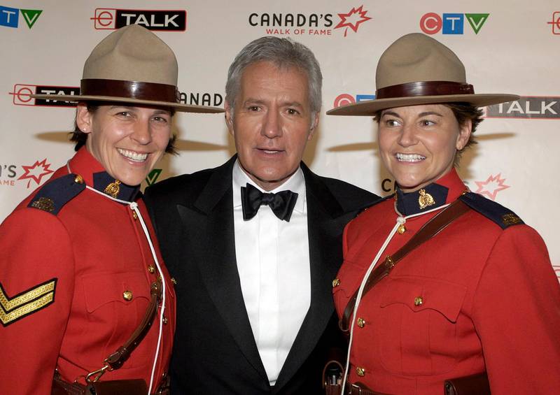 epa08808373 (FILE) - TV game show host Alex Trebek (C) poses with Canadian Mounties Mia Poscente (L) and April Dequanne backstage at the ninth annual Canada's Walk of Fame ceremony in Toronto, Canada, 03 June 2006 (reissued 08 November 2020). Alex Trebek, legendary host of TV game show Jeopardy, has died on 08 November 2020 at the age of 80, media report.  EPA/WARREN TODA
