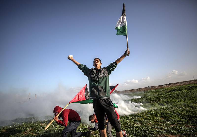 epaselect epa07353470 Palestinian protesters take cover from Israeli tear-gas during clashes after Friday protests near the border between Israel and Gaza Strip, east Gaza, 08 February 2019. According to local media reports, Two Palestinians 14 and 17 years-old boys were shot dead allegedly by Israeli snipers during clashes along the border between Gaza Strip and Israel. Palestinian protesters call for the right of Palestinian refugees across the Middle East to return to homes they fled in the war surrounding the 1948 creation of Israel.  EPA/MOHAMMED SABER