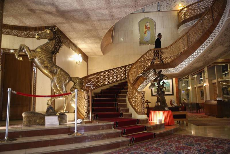 An employee walks up a grand staircase in the lobby of the Abbasi Hotel in Isfahan.  