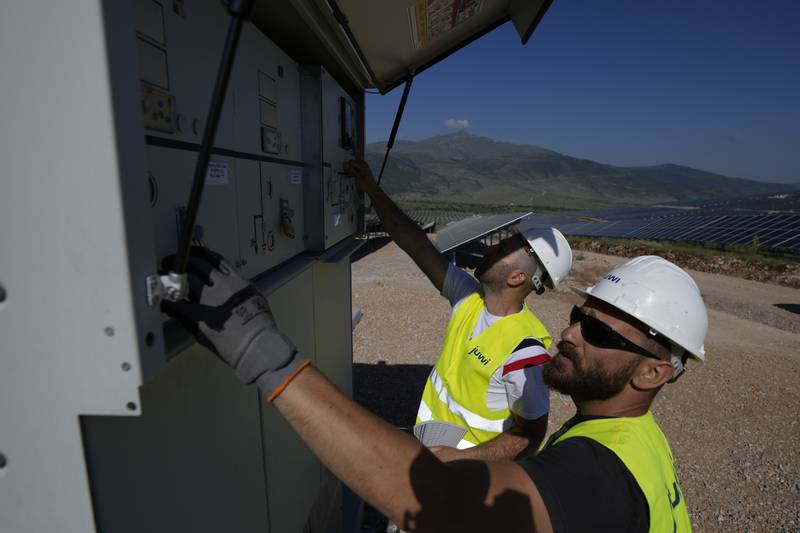 Maintenance engineers check installations at a new solar park outside the northern Greek city of Kozani.  A new report says that clean energy now provides more employment than the fossil fuel industry. AP