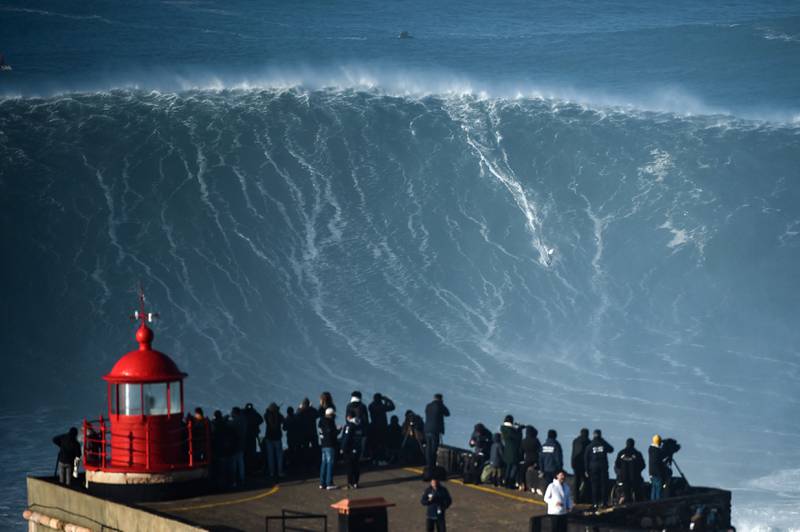 People watch a surfer during a big wave surfing session at Praia do Norte in Nazare, Portugal, on Saturday, January 8. AFP