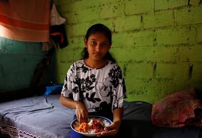 Dilhani Wathsala, 14, eating lunch cooked by Gunasekera, her mother. 'Before the economic crisis, we ate well and we served meat or fish to our kids at least three or four times a week. Now fish is out of the reach of our family and so is meat,' said Gunasekera. 
