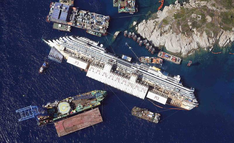 The Costa Concordia lies on its side next to Giglio Island before being rolled off the seabed and onto underwater platforms. The cruise ship capsized and partially sank in 2012. Reuters