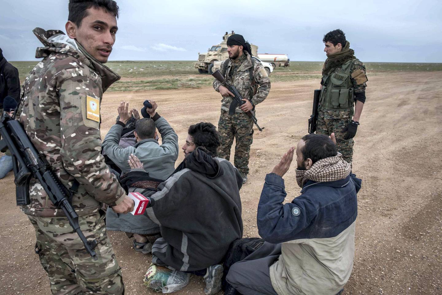 Men suspected of belonging to ISIS are screened by Syrian Democratic Forces after fleeing from the last pocket of territory held by the group outside Baghouz, Syria, 28 February 2019. Campbell MacDiarmid