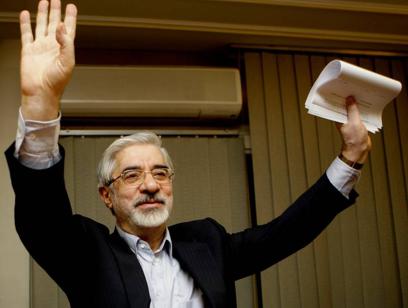 FILE - This Friday, June 12, 2009, file photo, shows Iranian reformist presidential candidate Mir Hossein Mousavi waving to the media during a late night press conference after polls closed in Tehran.  A website long associated with detained opposition leader Mir Hossein Mousavi has quoted him as comparing a crackdown on protesters under Iranâ€™s supreme leader to another carried out under the countryâ€™s ousted shah. The comments published Saturday, Nov. 30, 2019, represent some of the harshest yet attributed to Mousavi, a 77-year-old politician whose disputed election loss in 2009 led to widespread protests before being put down by security forces. (AP Photo/Kamran Jebreili)