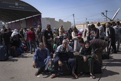 Palestinians wait to cross into Egypt at the Rafah border crossing. AP