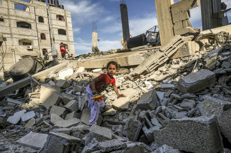 A Palestinian girl climbs on the remains of a building that was destroyed during an Israeli air strike on Rafah in the southern Gaza strip on May 5, 2019. - Gaza militants fired fresh rocket barrages at Israel early today in a deadly escalation that has seen Israel respond with waves of strikes as a fragile truce again faltered and a further escalation was feared. (Photo by SAID KHATIB / AFP)