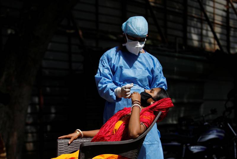 A healthcare worker takes a swab from a migrant laborer for a rapid antigen test in New Delhi. Reuters