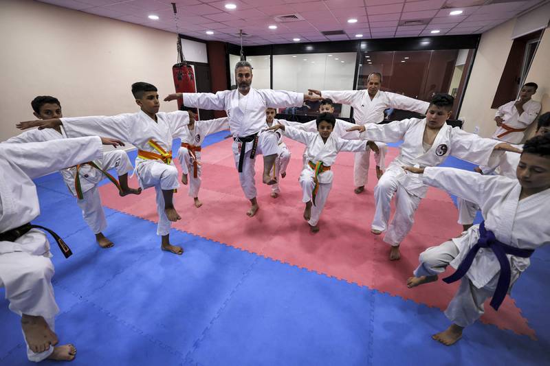 Karate students demonstrate a crane pose.
