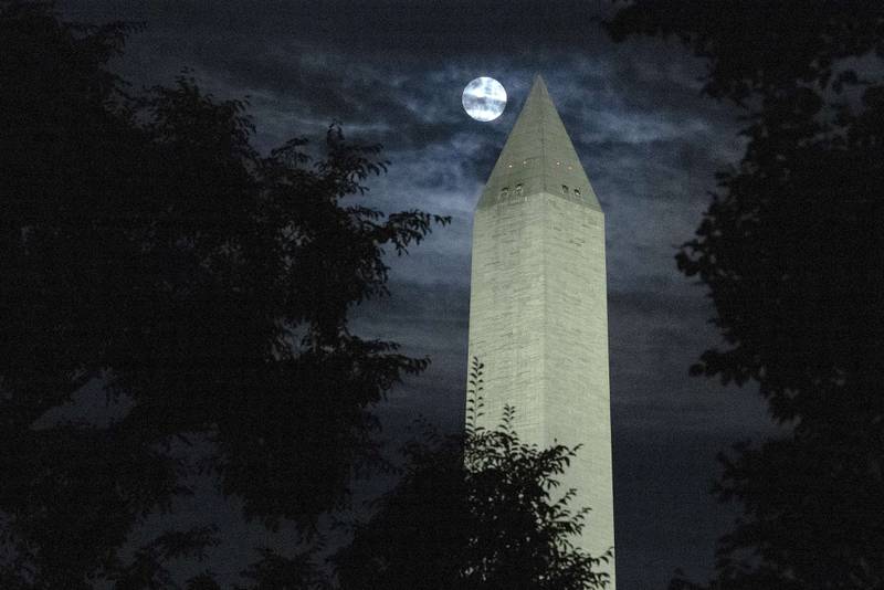 The moon is obscured by clouds as it passes behind the Washington Monument in the US capital. AFP
