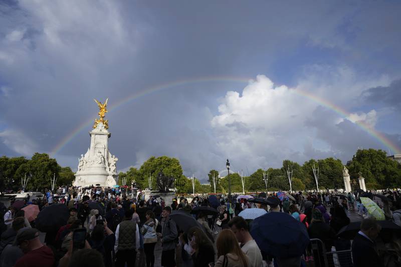 People gather outside Buckingham Palace in London as a double rainbow appears in the sky, Thursday, Sept.  8, 2022.  Buckingham Palace says Queen Elizabeth II has been placed under medical supervision because doctors are "concerned for Her Majesty's health. " Members of the royal family traveled to Scotland to be with the 96-year-old monarch.  (AP Photo / Frank Augstein)