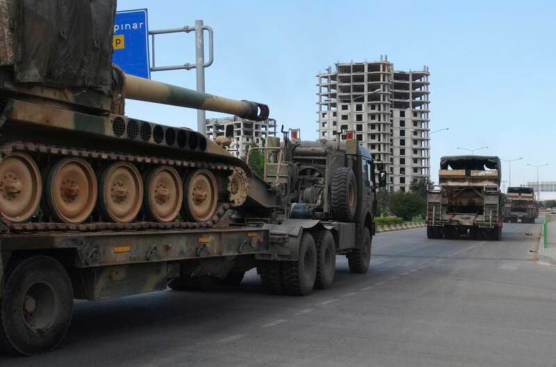 A convoy of Turkish military trucks carrying tanks destined for Syria, moves near the town of Kilis, Turkey, Friday, Sept. 14, 2018.  A senior official has confirmed that Turkey has reinforced Turkish troops manning 12 security posts around the Syrian province of Idlib as the Syrian army prepares for a military offensive to reclaim control.  Turkey deployed hundreds of soldiers at 12 observation posts that ring Idlib, following a de-escalation agreement it reached with Russia and Iran last year. (Resit Celebioglu/DHA via AP)