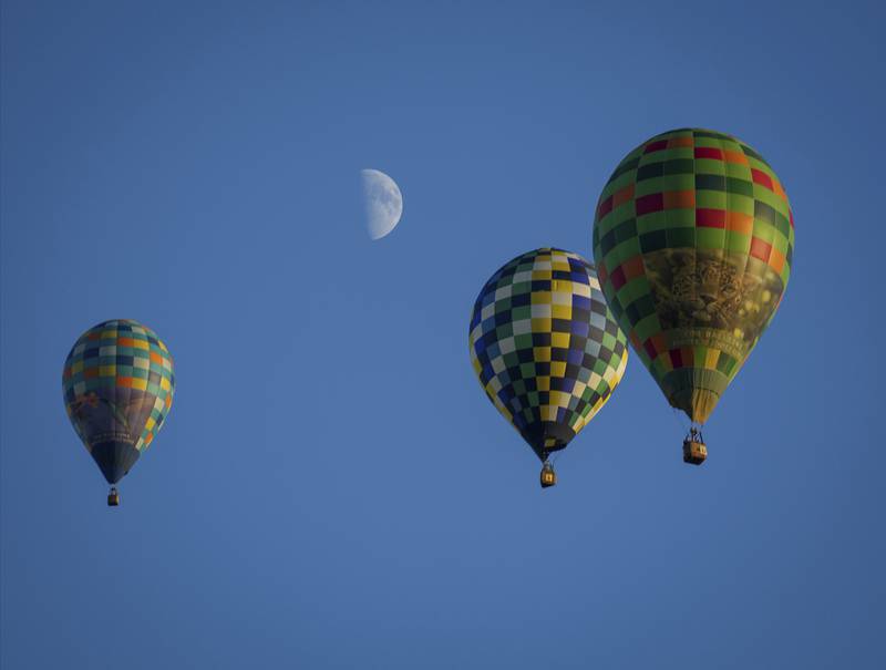 A trio of hot air balloons soar across the sky south of Indianola, Iowa during the National Balloon Classic. The Des Moines Register via AP