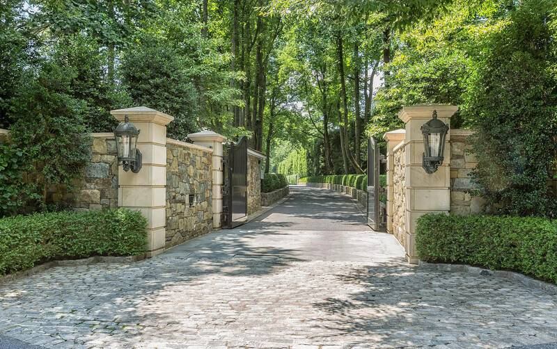Grand gates attached to limestone columns usher guests in. Photo: Bright MLS / Zillow