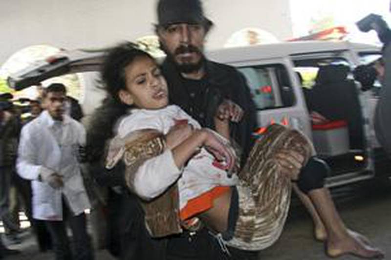 A Palestinian man carries a wounded girl to Shifa hospital in Gaza City.