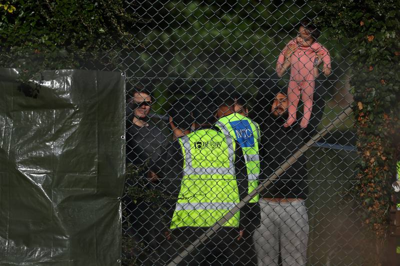 A man holds up a baby in the immigration processing centre. Reuters
