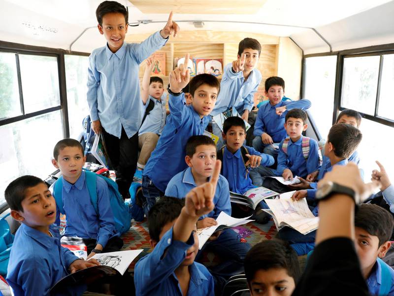 School boys are seen inside inside a mobile library bus.