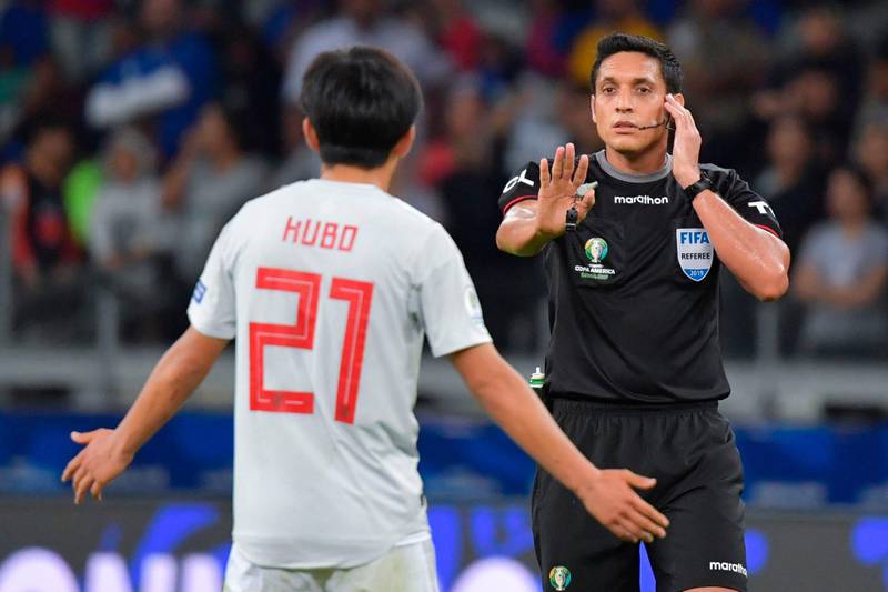 Venezuelan referee Jesus Valenzuela consults the VAR before disallowing a goal by Japan's Takefusa Kubo. AFP