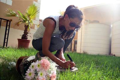 Patricia Assaad writes a message on a stone which will be placed at the burial site of six-week old Little Junior. Ravindranath K / The National