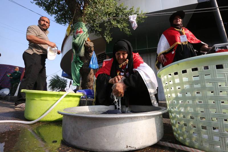 Iraqi women volunteer to wash the clothes of protesters by hand during continuing protests in central Baghdad against corruption, unemployment and appalling public services on November 12, 2019. Security forces in recent days have sought to crack down on rallies demanding regime change in Iraq, but protesters have kept up the movement with sit-ins across the capital and Shiite-majority south. / AFP / SABAH ARAR
