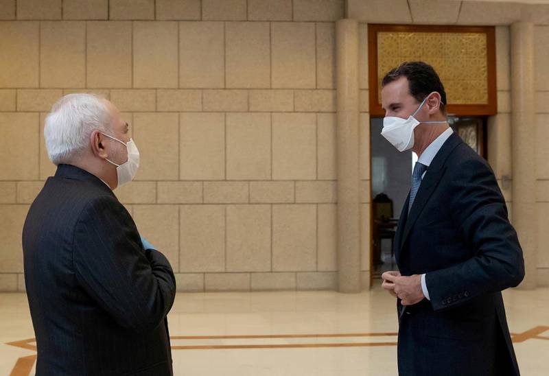 Syria's President Bashar al-Assad and Iran's Foreign Minister Mohammad Javad Zarif, wearing face masks as protection against the spread of the coronavirus disease (COVID-19), meet in Damascus, Syria, in this handout released by SANA on April 20, 2020. SANA/Handout via REUTERS ATTENTION EDITORS - THIS IMAGE WAS PROVIDED BY A THIRD PARTY. REUTERS IS UNABLE TO INDEPENDENTLY VERIFY THIS IMAGE     TPX IMAGES OF THE DAY