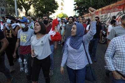 People hold Lebanese flags and chant as they mark the first anniversary of anti-government protests. Getty Images