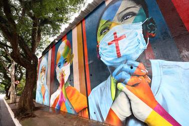 SAO PAULO, BRAZIL - MAY 22: A mural created by Brazilian artist Eduardo Kobra, which is dedicated to all victims of the COVID-19 pandemic, stands above a sidewalk on May 22, 2021 in Sao Paulo, Brazil. COVID-19 has now killed more than 1 million people in Latin America and the Caribbean, with nearly half of those killed in Brazil. Only three percent of the population of Latin America have been fully vaccinated against COVID-19. Health experts are warning that Brazil should brace for a new surge of COVID-19 amid a slow vaccine rollout and relaxed restrictions. The state of Sao Paulo has registered over 3 million cases of COVID-19 and more than 100,000 deaths. Over 445,000 people have been killed in Brazil by COVID-19, second only to the U.S. (Photo by Mario Tama/Getty Images)