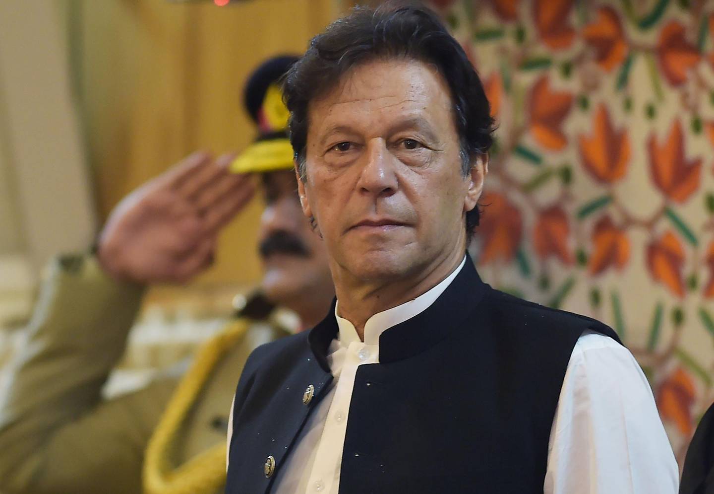 Pakistan's Prime Minister Imran Khan listens to the national anthem as he arrives at the legislative assembly in Muzaffarabad, the capital of Pakistan-controlled Kashmir on August 14, 2019 to mark the country's Independence Day. His visit to mark the country's Independence Day comes more than a week after Indian Prime Minister Narendra Modi delivered a surprise executive decree to strip its portion of the Muslim-majority Himalayan region of its special status. / AFP / AAMIR QURESHI
