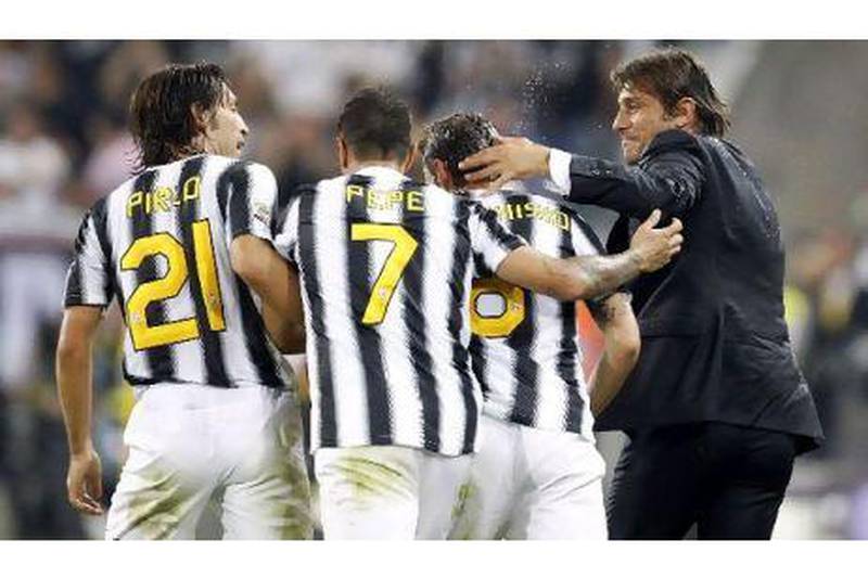 Antonio Conte, right, the Juventus coach, celebrates with his players, from left to right, Andrea Pirlo, Claudio Marchisio and Simone Pepe during their 2-0 win over AC Milan on Sunday.