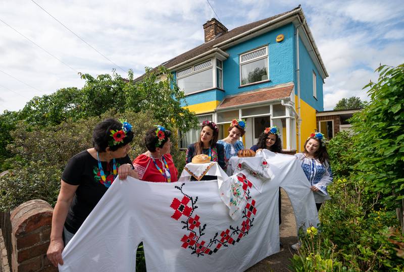 On Thursday Kristina Korniiuk, third right, who fled Ukraine after the Russian invasion, marks Vyshyvanka Day with a giant traditional shirt, at the home of her host Rend Platings in Cambridge. PA