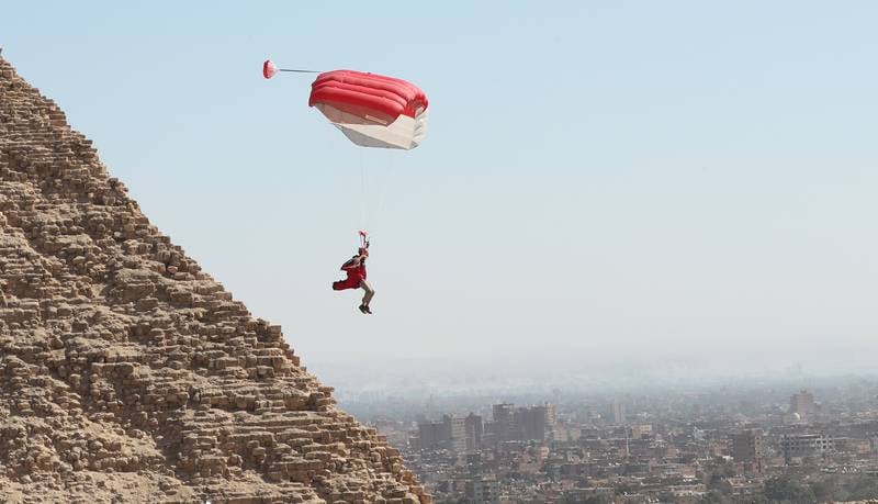 A skydiver flies over the Great Pyramids, which are the oldest of the Seven Wonders of the Ancient World.