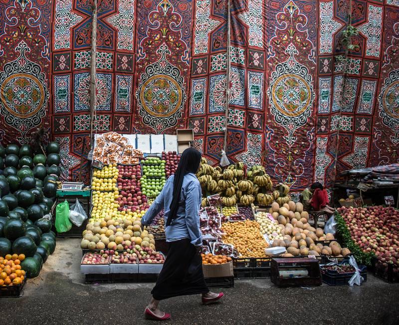 An Egyptian woman walks past a fruit stand at a market in the Egyptian capital, Cairo, on May 15, 2017.
Ramadan is a time for daytime fasting and lavish evening feasts, but Egyptians are scaling back preparations for the Muslim holy month this year after austerity measures fuelled decades-high inflation. / AFP PHOTO / KHALED DESOUKI