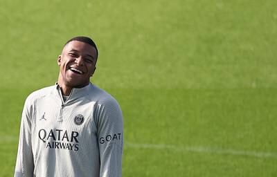 PSG forward Kylian Mbappe enjoys a joke during training. AFP