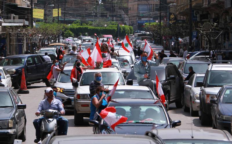Anti-government demonstrators hold Lebanese flags during a protest in their cars, amid a countrywide lockdown to combat the spread of the coronavirus disease in Tripoli, Lebanon.  Reuters