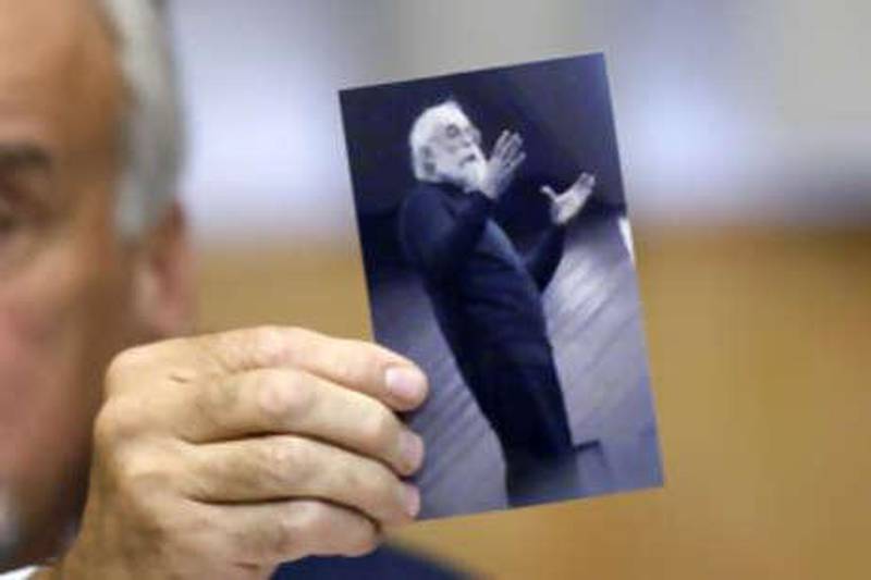 The Serbian chief war crime prosecutor Vladimir Vukcevic shows a picture of Radovan Karadzic during a news conference in Belgrade today. Mr Karadzic was arrested on Monday near Belgrade posing as a doctor of alternative medicine, sporting long hair, a beard and glasses to hide his face.