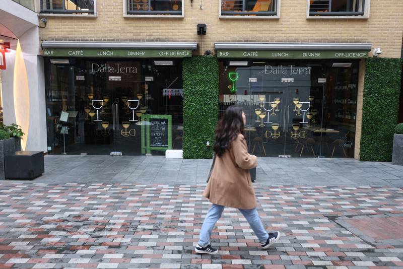 A woman passes a closed food outlet in Covent Garden, London, after a rapid rise in Covid-19 case numbers led to a surge in booking cancellations across the hospitality industry. PA