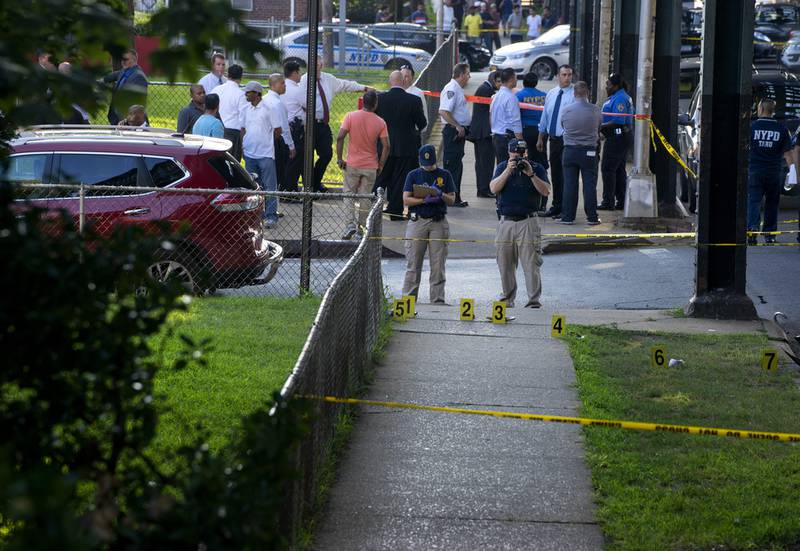 New York police department crime scene investigators photograph evidence  on Saturday, Aug. 13, 2016, in the Queens borough of New York, after the leader of a mosque and an associate were shot dead as they left afternoon prayers. AP Photo/Craig Ruttle