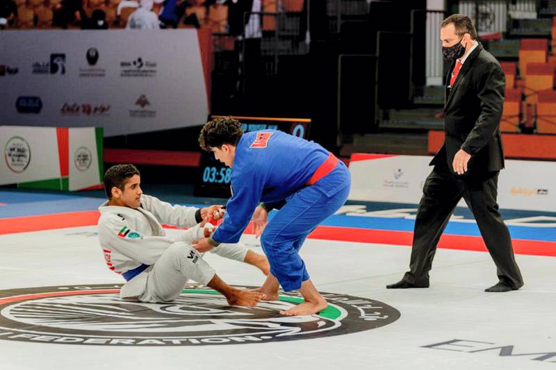Faraj Al Awlaqi (white kimono) takes guard against Brazilian Bernardo Schirmer in the Abu Dhabi World Youth Championship at the Jiu-Jitsu Arena on Tuesday, April 6, 2021. Courtesy UAEJJF 