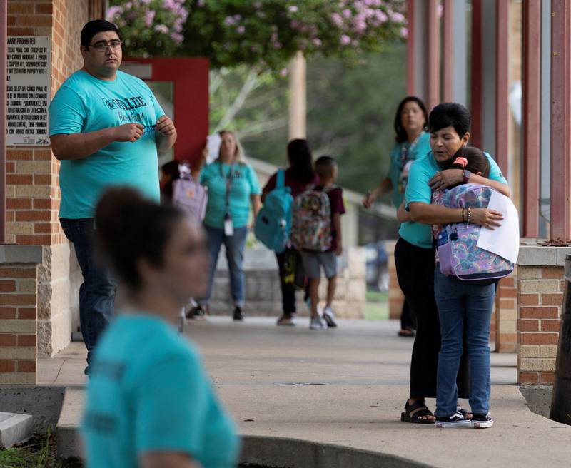 Personnel from Uvalde Elementary School greet pupils as they return after the summer break. Reuters
